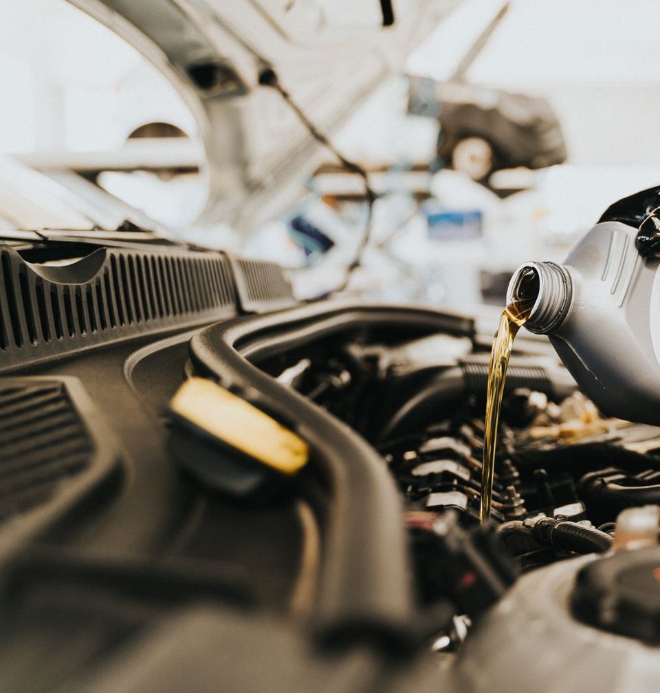 Licensed stock photograph: fresh oil being poured into a car engine.
